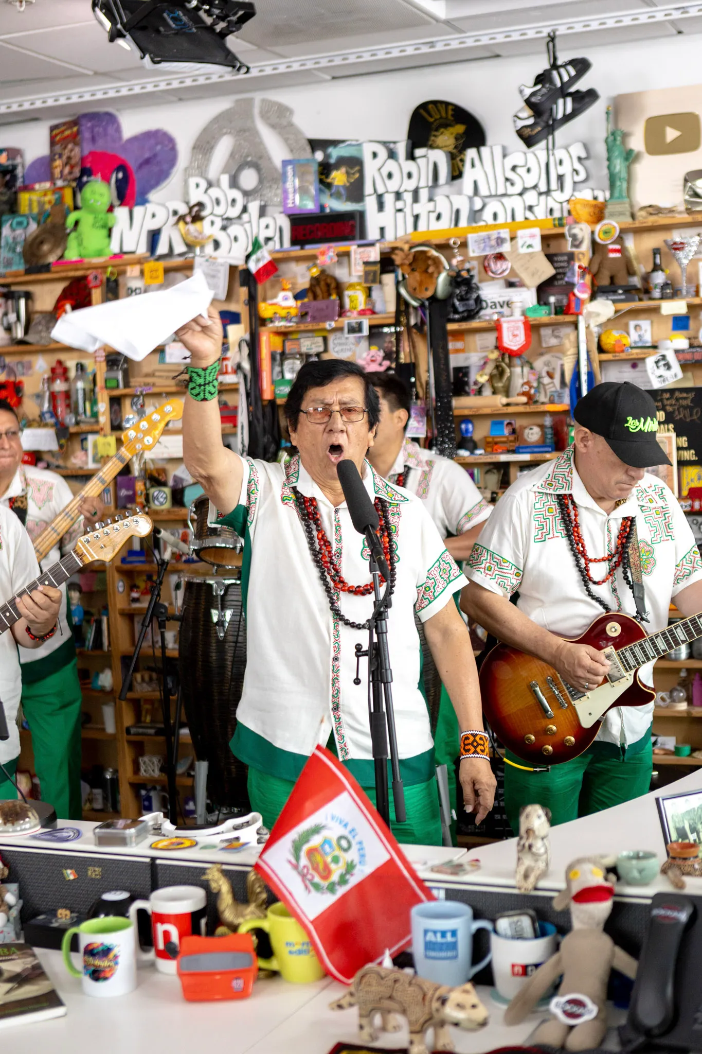 Jorge Rodríguez, fundador de Los Mirlos, canta con el brazo en alto y una camisa bordada con arte kené