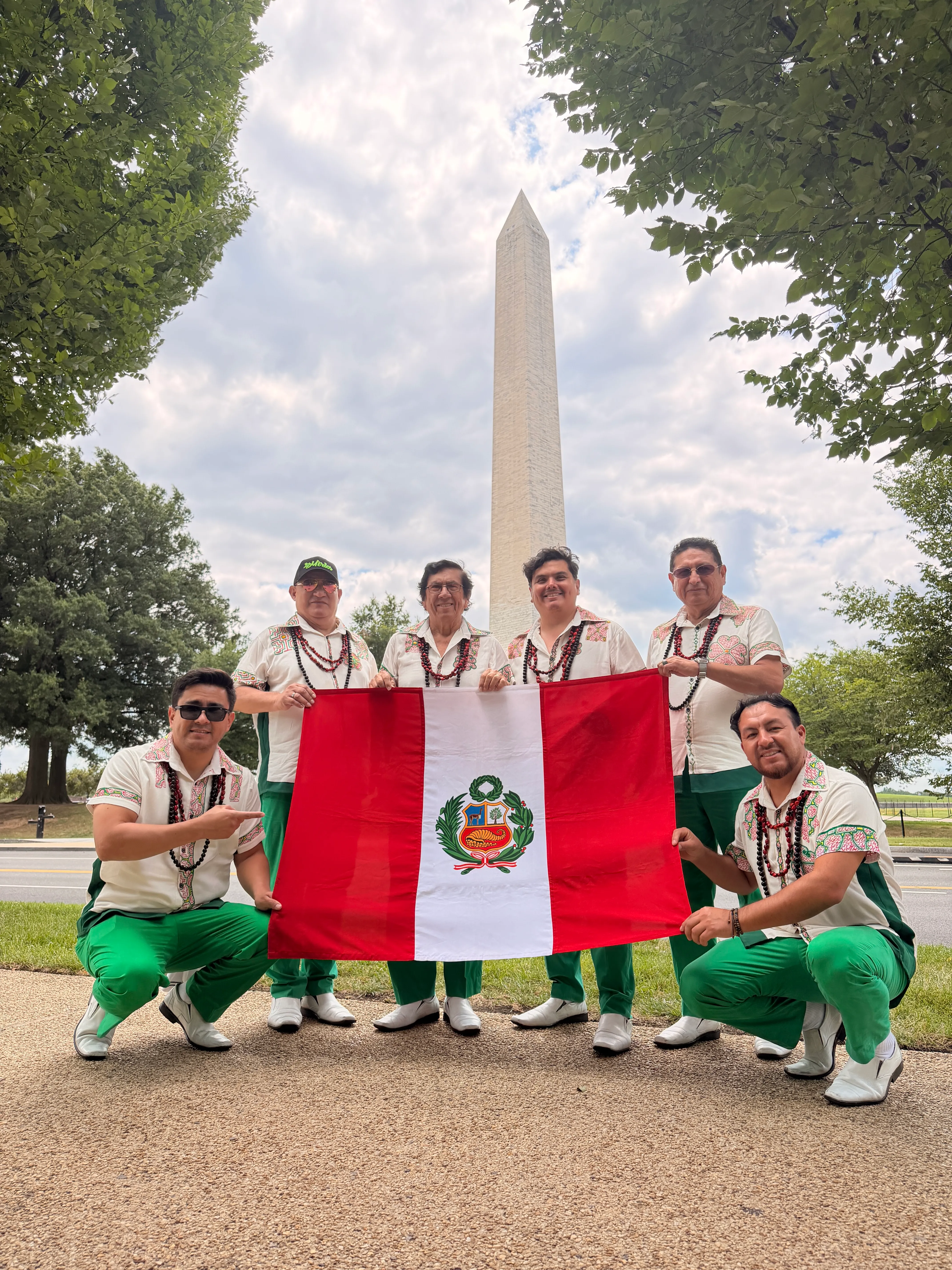 Los Mirlos sostienen una bandera del Perú frente al Monumento a Washington
